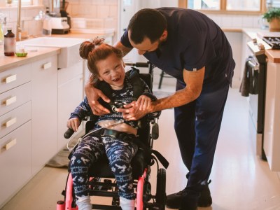 little girl in wheelchair with father